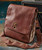 Where I Wander leather messenger bag, brown textured leather strap bag with metal clasp and zipper detailing.