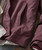 Cut The Deck, close-up image of a burgundy jacket with a side pocket, zipper, and detailed stitching.