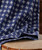 Got My Plans Squared Away, a fabric with a navy blue background and white geometric pattern, draped over a wooden surface.