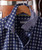 Got My Plans Squared Away, patterned blue shirt with white designs hanging on a wooden hanger.
