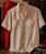 Break It Up, beige short-sleeve textured button-up shirt with two chest pockets hanging on a wooden hanger.