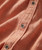 Side Effects, close-up view of a peach-colored fabric shirt with buttons and textured material details.