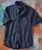 Boomerang, black short-sleeve shirt with a textured zigzag pattern and a front pocket.