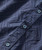 Boondoggle Boomerang, close-up of a navy blue shirt with geometric embossed pattern and blue buttons.