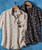 Papa's Gettin' Hot, two floral patterned shirts hanging on a wooden hanger against a blue background with sunglasses clipped to one shirt.