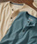 Spontaneous Simplicity, two casual button-up shirts in cream and blue laid flat on a wooden surface.