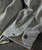 Bits Of Blues, close-up image of a light-colored denim shirt with blue speckled pattern, showing buttoned cuff and detailed fabric texture.