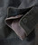 Can I Get It? , close-up of a men's dark gray suit with a checked pattern, showing the detailed stitching, buttons, and inner lining of the shirt cuff.