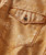 Early A.M. Attitude, close-up of a tan denim shirt with a single buttoned flap pocket and red stitching detail.