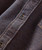 Water To Wine, close-up image of a textured, patterned fabric shirt with a button detail.