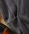 Shadows, fabric of a garment with detailed stitching and texture in dark colors.