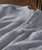 Waves Within, striped gray and white sweater featuring a button detail.