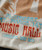 Just Another Whistle Stop, close-up of vintage-style graphic print on fabric featuring orange, blue, and white colors with text mentioning Cleveland, Ohio, 1970, and a design reminiscent of concert or event memorabilia.