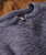 Thump And Bump, close-up image of a gray textured ribbed knit shirt or sweater fabric with frayed edges.