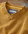 Soulshine, a mustard yellow textured knit sweater with a ribbed collar and neckline.