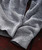 Blues Blues Blues, close-up of a cozy, knitted gray and navy sweater fabric with detailed stitching and texture.