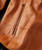 Make My Getaway, close-up image of a brown leather jacket with a zipper detail.