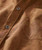 Shake My Tree, close-up of a brown patterned shirt with visible stitching and a chest pocket, featuring black and white buttons.
