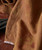 Shake My Tree, close-up of brown fabric with leaf print and stitched hem detail.