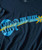 Product Blue Guitar Blues, close-up of a navy blue t-shirt with a graphic design featuring a blue guitar, yellow starfish, and the phrase 'Keeping the Blues Alive' in blue and yellow text.