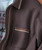 Time Change, close-up of a men's brown textured jacket with a pocket and striped trim details.