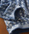 Drifting Blues, close-up of a blue and white patterned knitted sweater with intricate checkered design and ribbed cuffs.