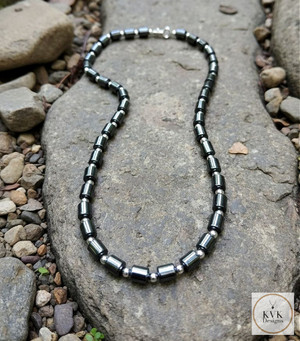 Hematite Barrel Bead Necklace sitting on rocks outside