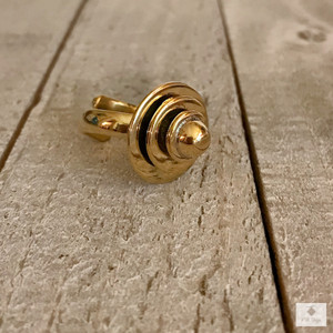 Geometric Circle Brass Ring on wood surface facing sideways Geometric Circle Brass Ring on wood surface facing sideways