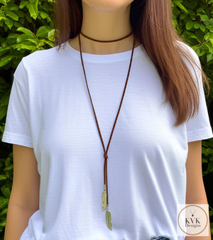 Boho Chic: Brown Suede Lariat Feather Necklace on our model wearing a white t-shirt