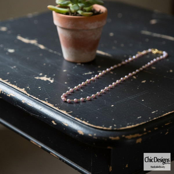 Purple Pearl & Crystal Statement Necklace - 28" Silver Chain laying on black distressed table