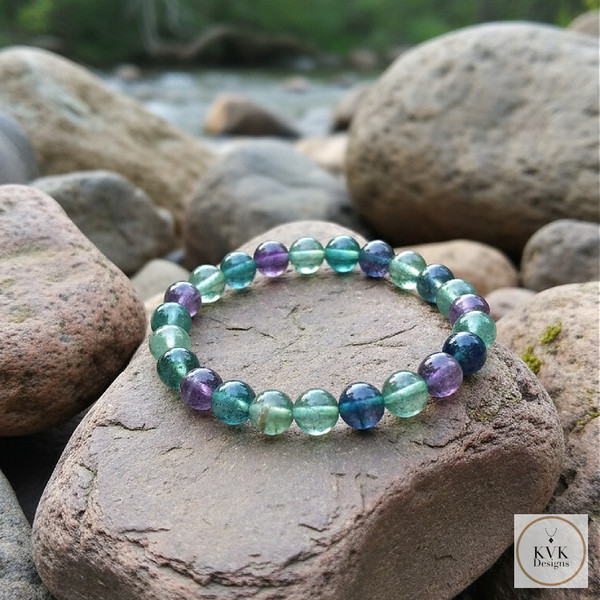Fluorite Bead Stretch Bracelet sitting on rocks outside