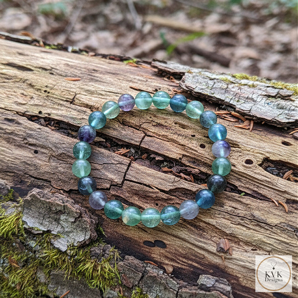 Fluorite Bead Stretch Bracelet laying on a log outside
