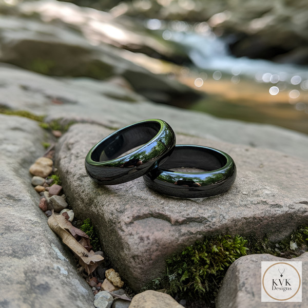 6mm Dome Hematite Rings sitting on rocks outside