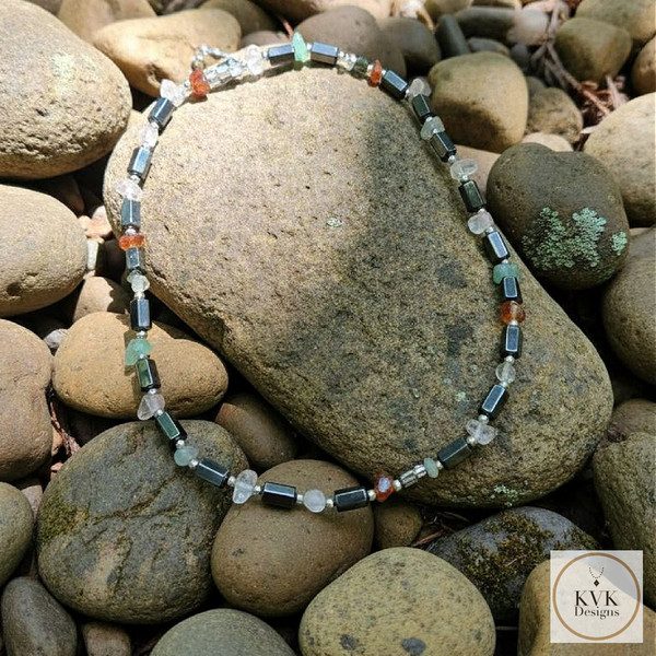 Semiprecious Stone & Hematite Necklace laying on rocks outside