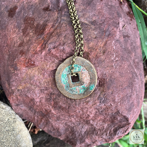 Antique Chinese Coin Necklace on rock