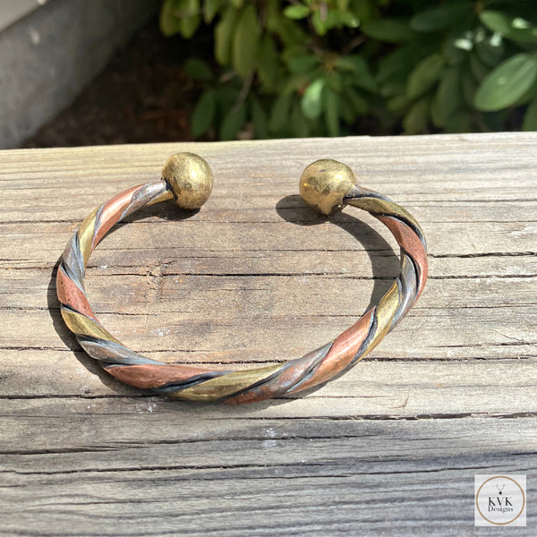 West African Woven Copper and Bronze Bracelet on Wood