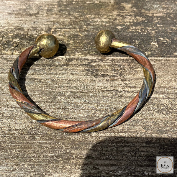 West African Woven Copper and Bronze Bracelet on Wood