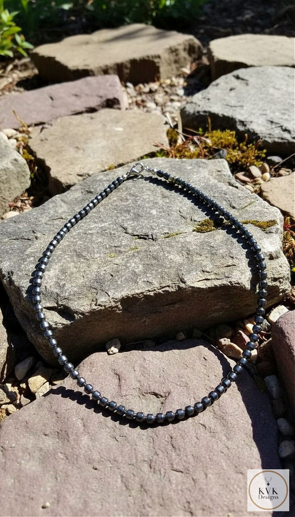 Faceted Hematite Bead Necklace sitting on rocks outsidelegant Faceted Hematite Beaded Necklace | 17 inches in length

This sophisticated necklace features precisely faceted hematite beads, meticulously strung to create a sleek, professional appearance. The 17-inch length sits perfectly at the collarbone, making it an ideal accessory for both business attire and evening wear. The natural metallic sheen of hematite provides a versatile, contemporary aesthetic that complements a variety of outfits.