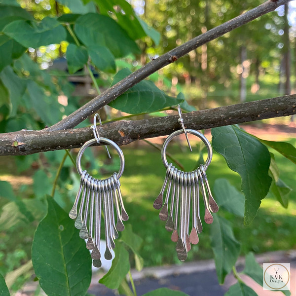 Boho Silver Metal Fringe Paddle Earrings hanging from a branch