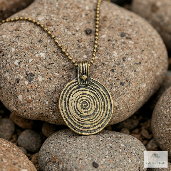 Bronze Swirl Pendant Necklace sitting on rocks