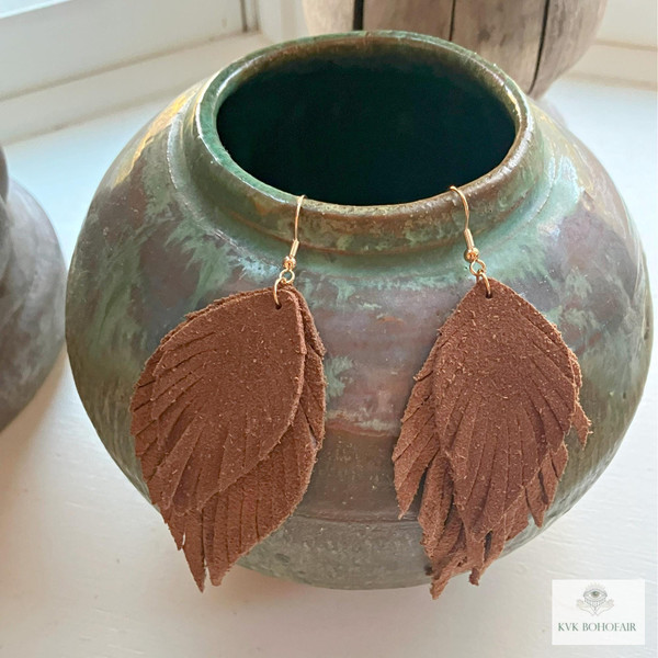 Boho Handcrafted Suede Feather Dangle Earrings hanging from old jug
