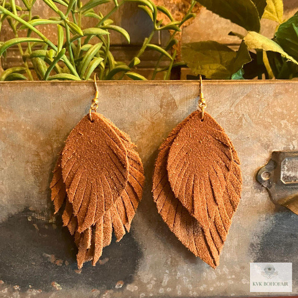 Boho Handcrafted Suede Feather Dangle Earrings hanging from metal box