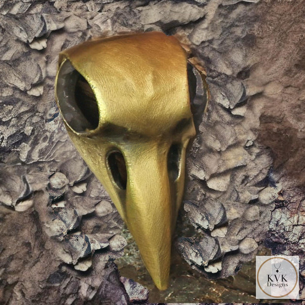 Brass Crow Skull Necklace Pendant sitting on a piece of wood