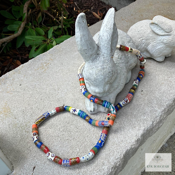 Long African Trade Bead Necklace draped over a stone bunny