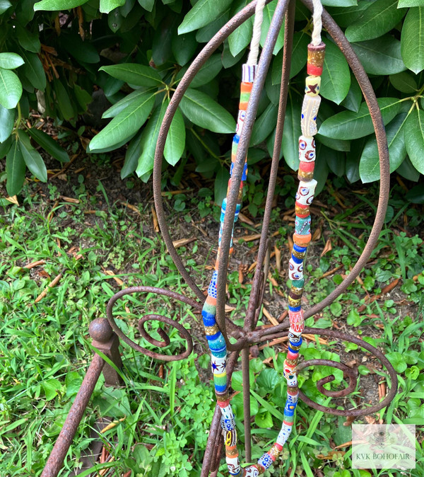 Long African Trade Bead Necklace hanging from a metal sculpture