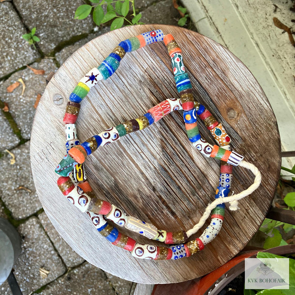 Long African Trade Bead Necklace laying on round wood