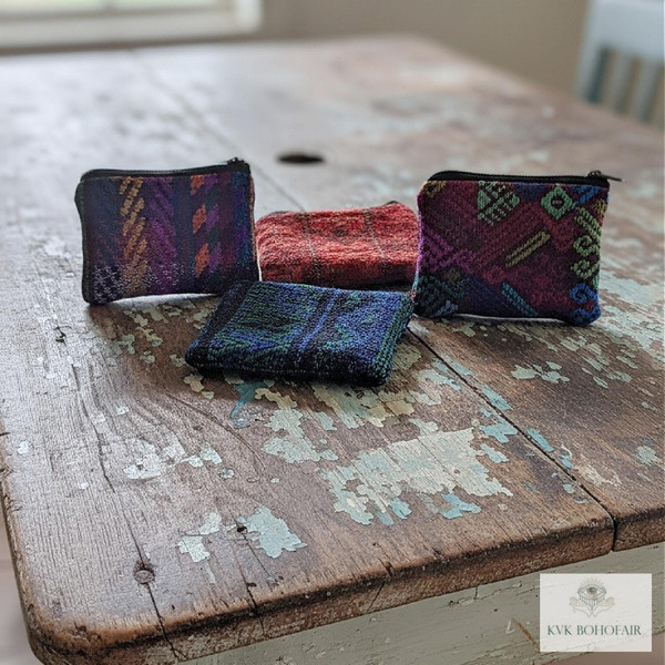 Group of Small Guatemalan Huipil Coin Purses sitting on a distressed table