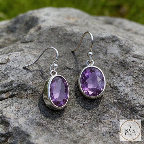Faceted Amethyst French Wire Earrings laying on rock outside