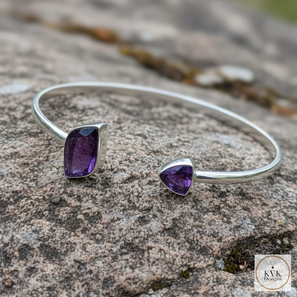 Sterling Silver Amethyst Open Cuff Bracelet laying on rocks outside