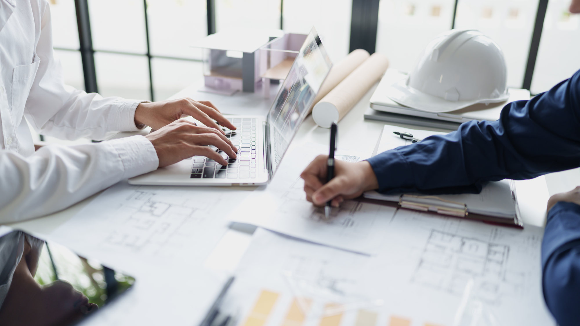 Engineers working on technical drawings and design plans for an industrial engineering project.